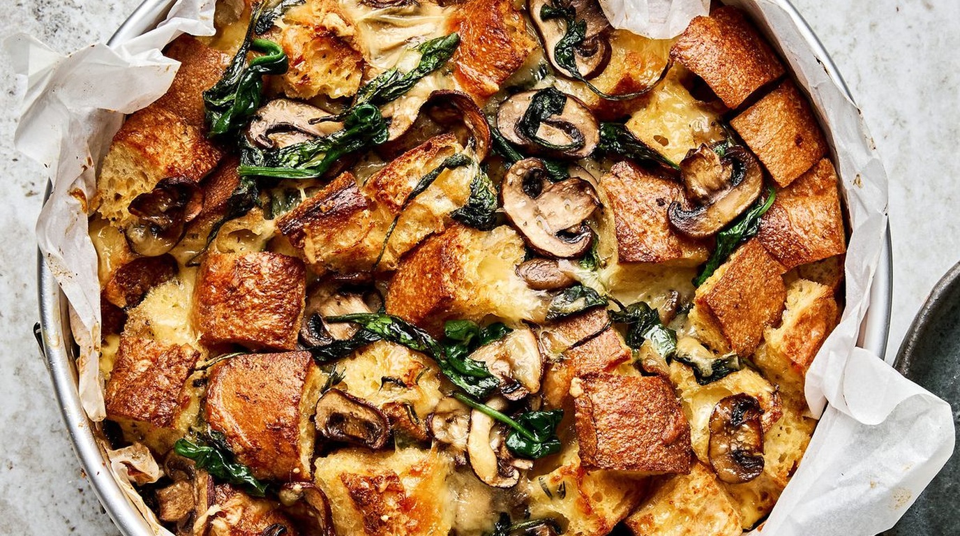 Ultra close-up macro of golden bubbling spinach mushroom breakfast strata fresh from the oven in a baking pan