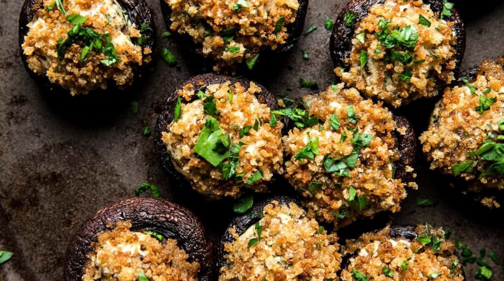 Ultra close-up macro of golden-baked garlic herb cream cheese stuffed mushrooms bubbling with browned panko topping