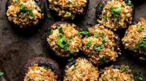 Ultra close-up macro of golden-baked garlic herb cream cheese stuffed mushrooms bubbling with browned panko topping