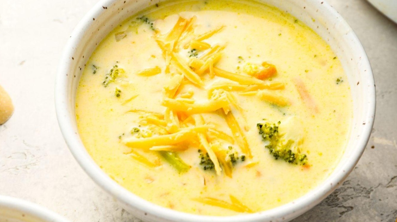 Ultra close-up macro of Panera copycat broccoli cheddar soup with melted cheese and broccoli florets