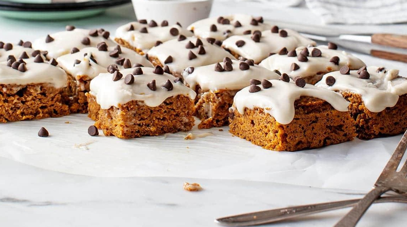 Ultra close-up macro of super moist pumpkin bars with thick cream cheese frosting and chocolate chips