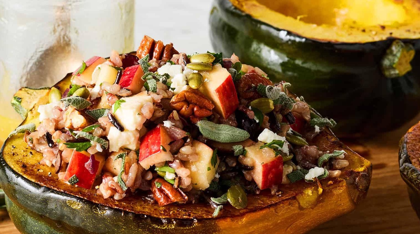 Ultra close-up macro of roasted stuffed acorn squash filled with wild rice, diced apples, and pecans