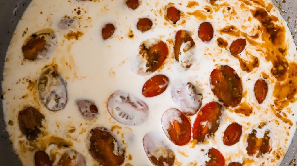 Ultra close-up macro of creamy tuscan garlic chicken in cast iron skillet
